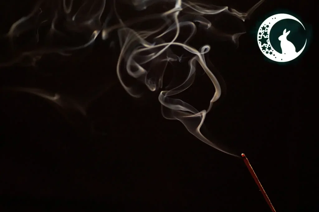 Oczyszczanie przestrzeni przed rytuałem - dym kadzidłła tle ciemnego nieba z symbolem królika w księżycu.